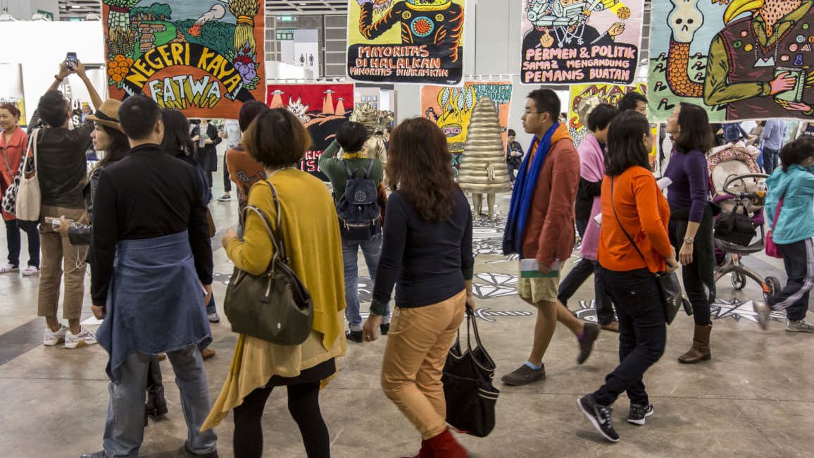 A group of people walking through an underground art space at Art Basel Hong Kong.