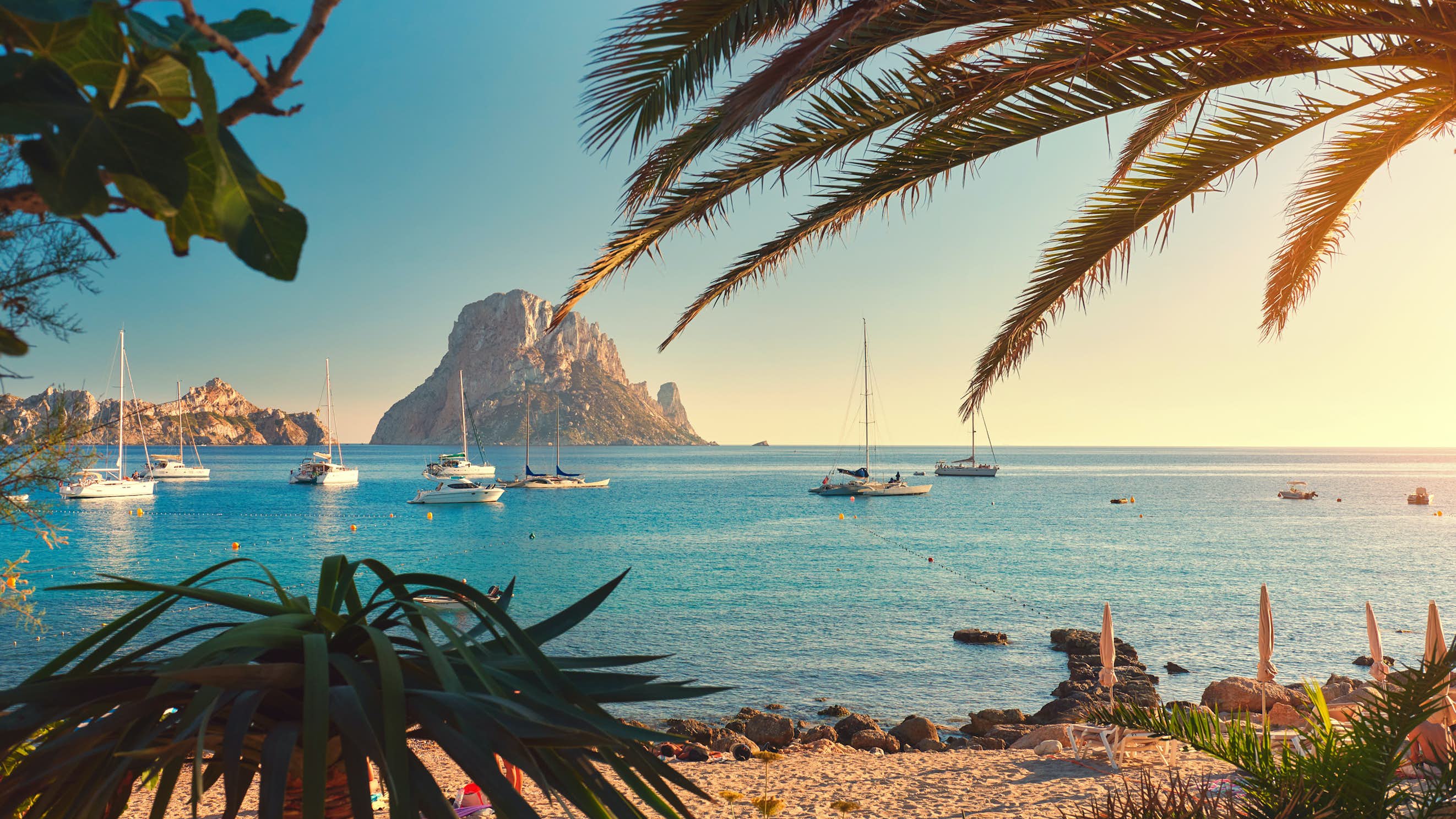 Ibiza Yacht Charter Mediterranean - Beach with boats on the horizon in Ibiza