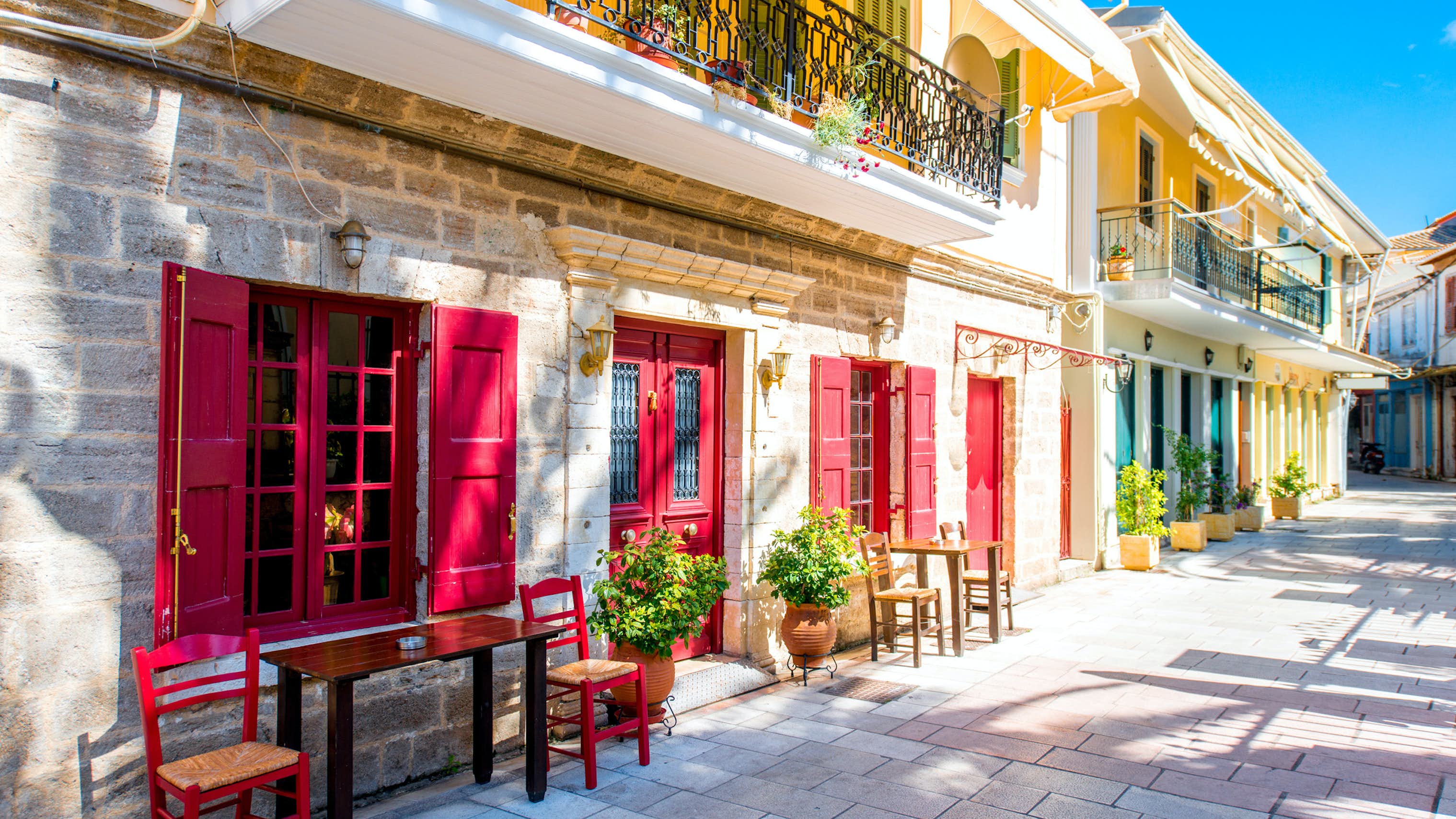 Yacht Charter Ionian Islands - Levkas, Ionian Islands, bright red doors on quiet street with small tables